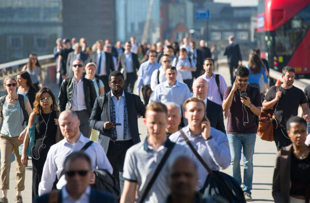 londra, regno unito. immagine offuscata degli impiegati che attraversano il london bridge la mattina presto sulla strada per la city di londra. - pendolare foto e immagini stock