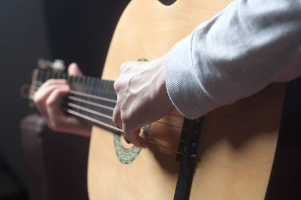 istock Young woman's hands playing a acoustic classic guitar 953202234
