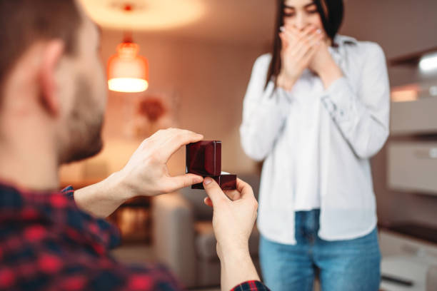 istock Young man makes an offer to surprised woman 953205528