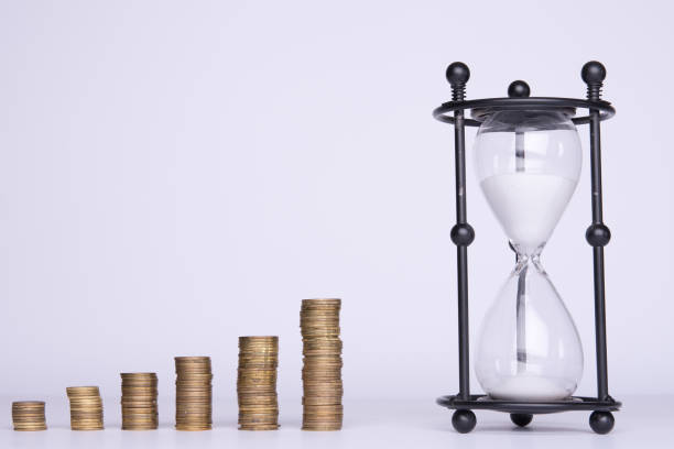 istock stacks of money and hourglass on a white background 953205646