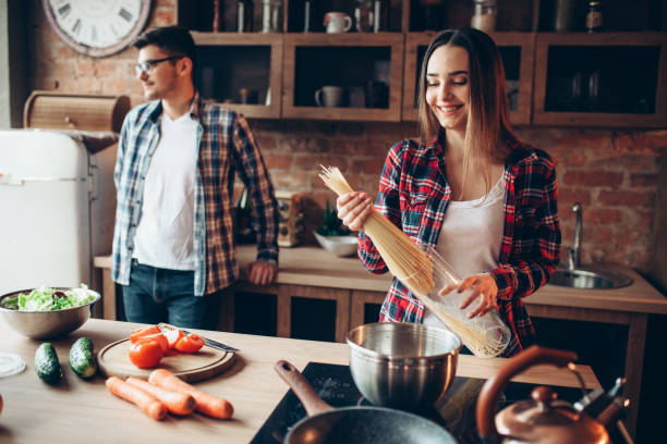istock Couple cooking fresh vegetable salad and spaghetti 953206078