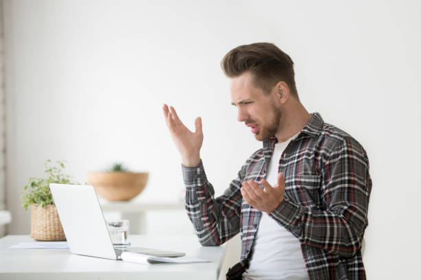 confused angry man frustrated by online problem, hate stuck laptop - frustration computer confusion businessman imagens e fotografias de stock