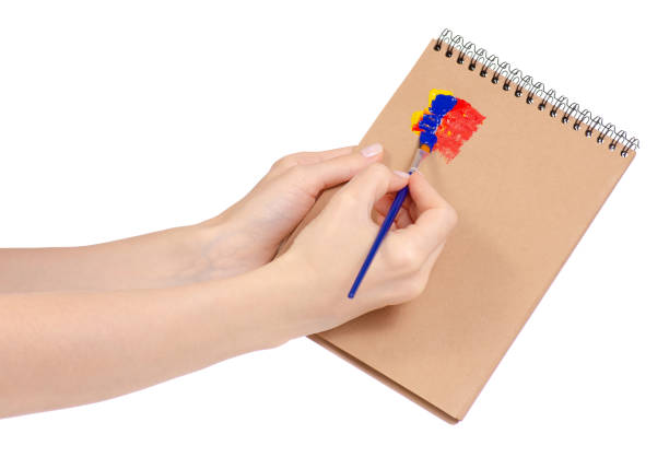 istock Notepad for drawing and brush with paint in hand 953226358