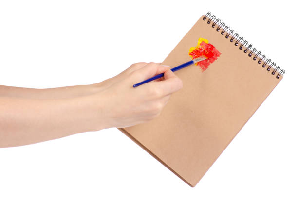 istock Notepad for drawing and brush with paint in hand 953226382
