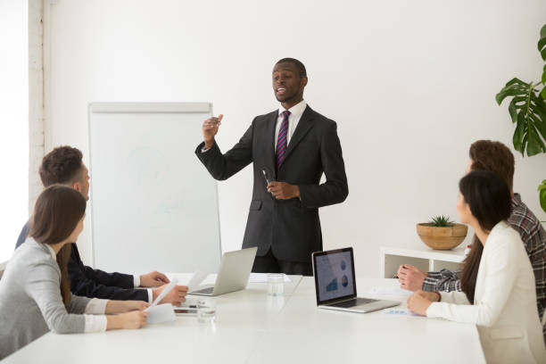 istock Confident african speaker or business coach giving presentation to team 953226714