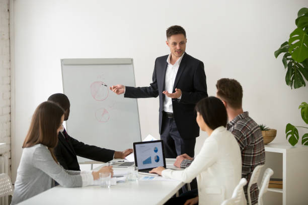 istock Successful team leader presenting new project to employees at meeting 953226732