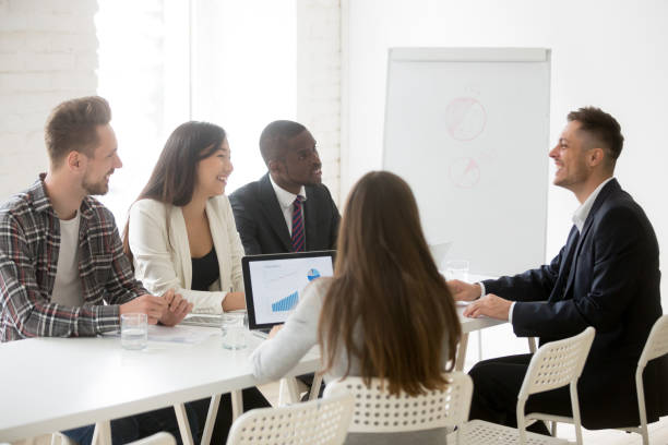 istock Smiling ceo leading meeting talking to multiracial team in office 953226740