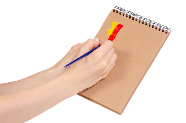 istock Notepad for drawing and brush with paint in hand 953229408