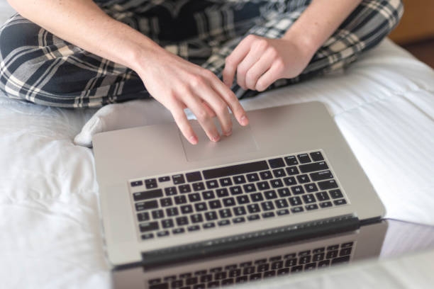 istock Low Section Of Man Using Laptop On Bed At Home 953232900