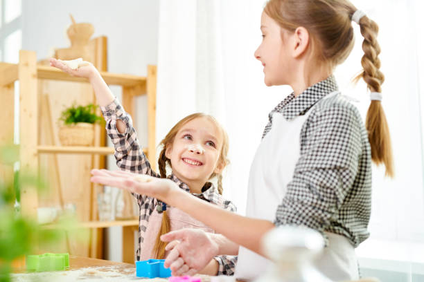 istock Little Sisters Preparing Cookies 953260500