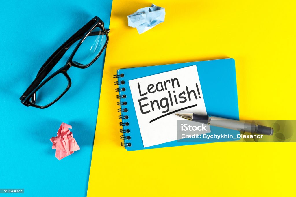 Learn english - note at blue and yellow background with teachers glasses Learn english - note at blue and yellow background with teachers glasses. English Language Stock Photo