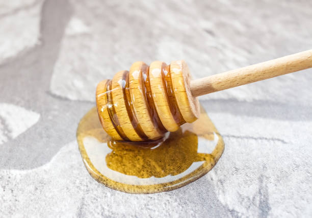 istock Honey spill and honey-spoon on kitchen counter 953264784