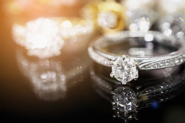 istock Jewelry diamond rings with reflection on black background 953267630