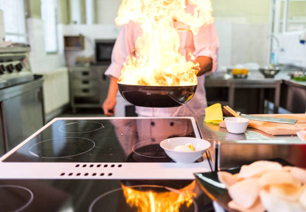 Chef cooking in asian restaurant, with his female assistant, burning.