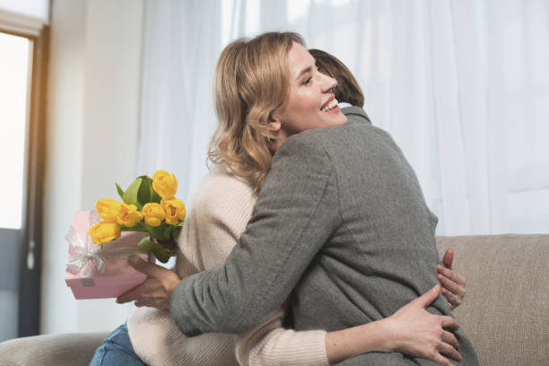 istock Beaming female embracing husband with presents 953268348