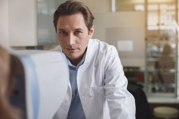 Focused ophthalmologist having job with appliance