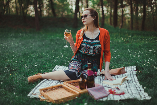 Beautiful young woman enjoying a picnic on a sunny day
