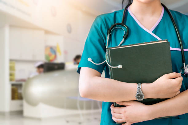 白い背景の上の緑の本を保持している看護師のイメージをトリミング - 大学院 ストックフォトと画像