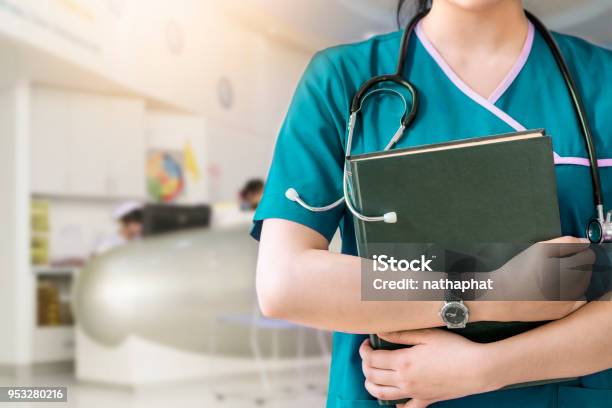 Cropped Image Of Nurse Holding Green Book On White Background Stock Photo - Download Image Now