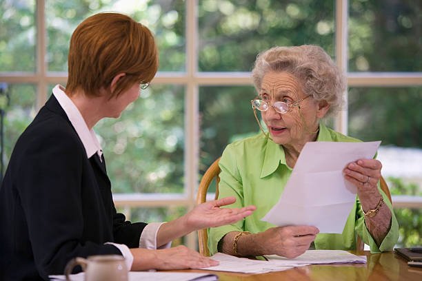 Senior woman meeting with agent Mature woman talking to financial planner at home will legal document stock pictures, royalty-free photos & images