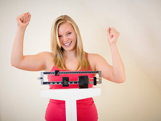 счастливая женщина на весы - weight loss стоковые фото и изображения