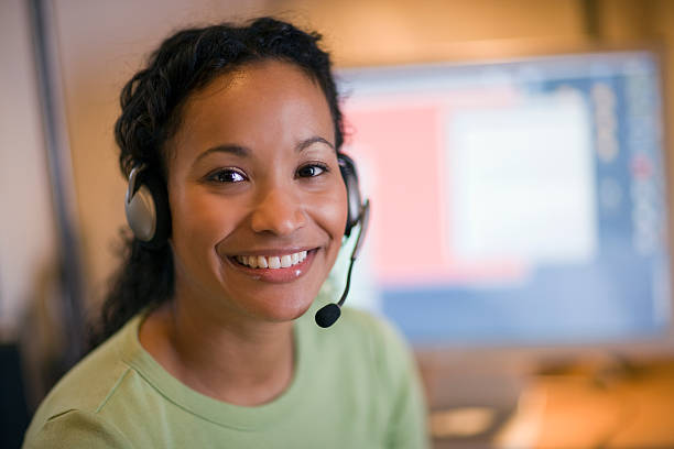 linda mulher com fone de ouvido preto - female customer service representative looking at camera technology - fotografias e filmes do acervo