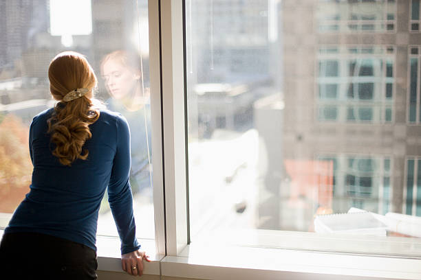 istock Businesswoman looking out office window 95340260