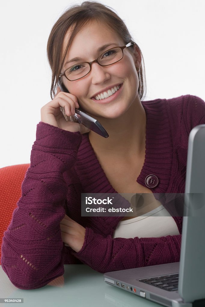 Giovane donna con telefono cellulare e computer portatile - Foto stock royalty-free di Abbigliamento casual