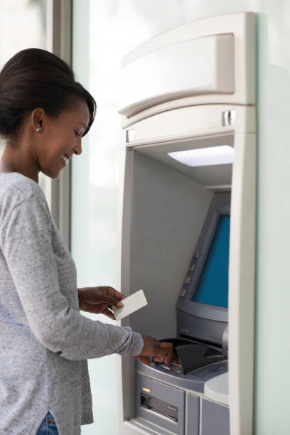 istock Woman using a bank ATM machine. 953423392