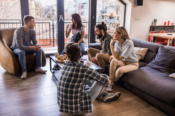 Group of happy people relaxing in the living room and communicating among themselves.
