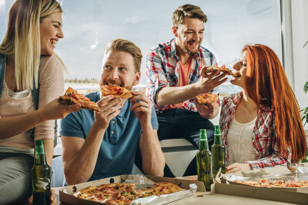 istock Happy friends talking and having fun while eating pizza at home. 953425444