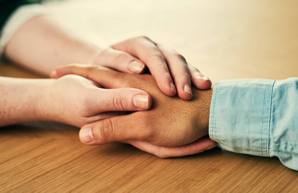 Keep each other close Cropped shot of a man and woman holding hands in comfort on a table woman comforting depressed friend stock pictures, royalty-free photos & images