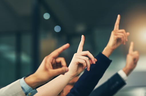 Cropped shot of a group of businesspeople raising their hands