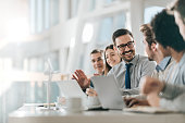 Happy businessman talking to his colleagues on a meeting in the office,