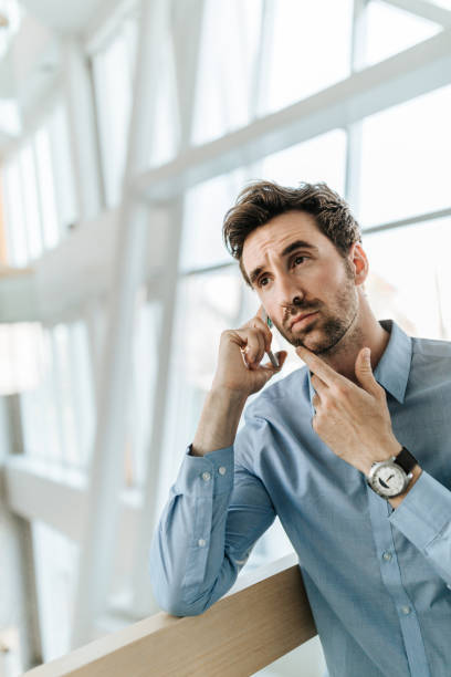 istock Thoughtful businessman talking on mobile phone in a hallway. 953426690