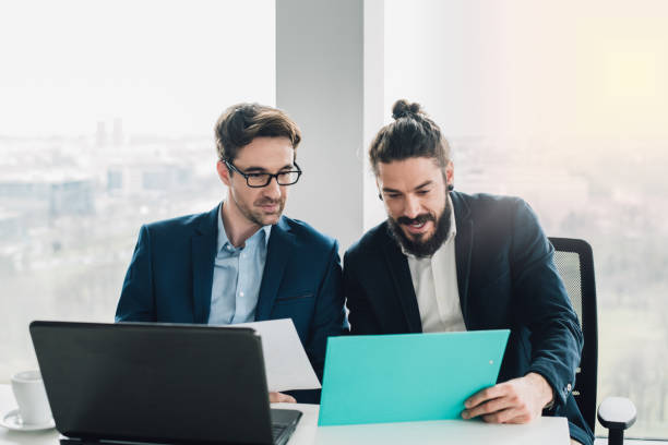 istock Coworkers looking at paperwork in office 953427502