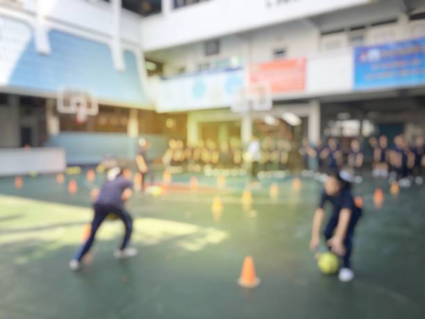 blurred image of children or male and female students in secondary school are learning football or soccer on school playground in physical education time. bangkok,thailand. physical activities concept - secondary action imagens e fotografias de stock