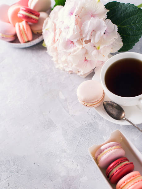 istock Macaroons and cup of coffee with flowers over white texture 953435104