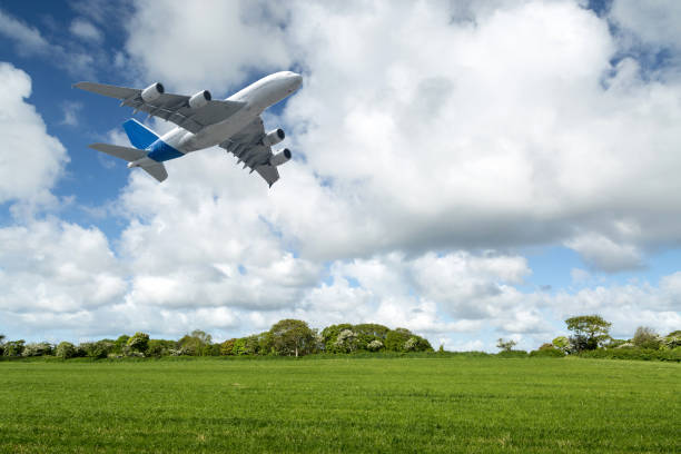 istock Flight of a passenger plane over the meadows 953437426