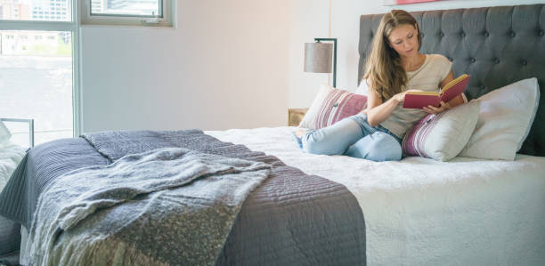 istock Woman reading book in bed 953439524
