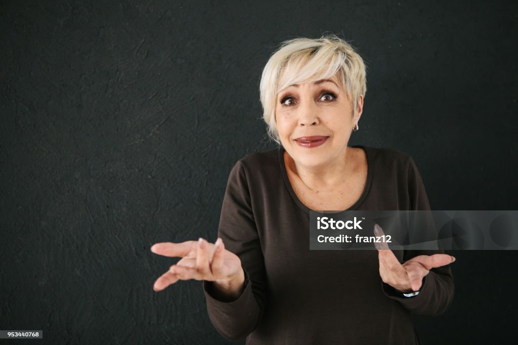 Eine ältere Frau, die betrogen wurde, oder sie nicht verstehen, was mit ihr passiert, zeigt durch Geste ein Fragezeichen mit ihren Händen - Lizenzfrei Frauen Stock-Foto