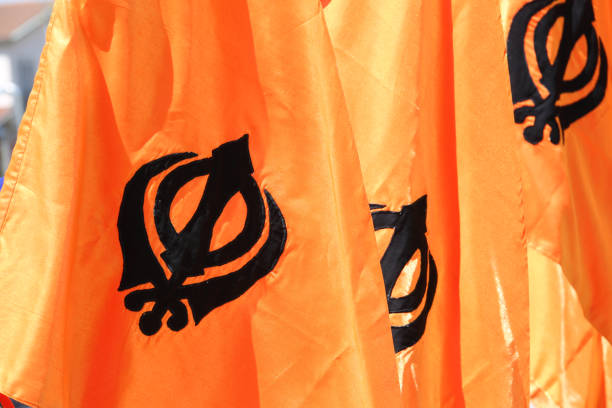 symbol of the Sikh religion called KHANDA formed by two scimitars on orange background