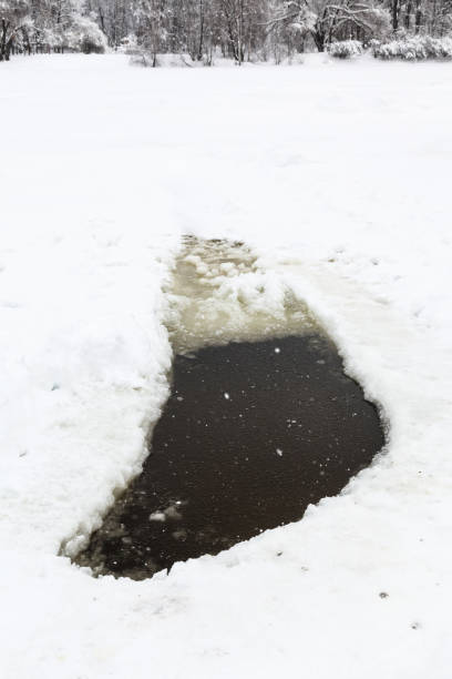 istock ice hole in frozen pond in winter snowfall 953442750
