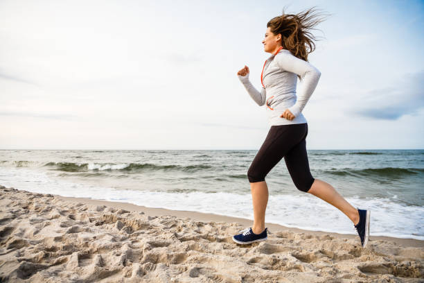 istock Young woman running on beach 953446186