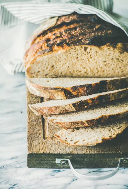 istock Freshly baked sourdough bread cut into pieces on rustic board 953446578