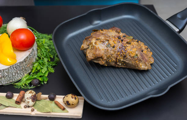 preparados de carne marinada em uma panela de grelhar ao lado de legumes em uma placa de madeira - meat quail game meat skillet - fotografias e filmes do acervo