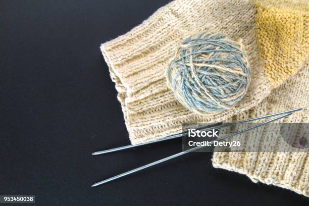 A Ball Of Wool With Knitting Needles And Socks On A Gray Table Needlework Stock Photo - Download Image Now