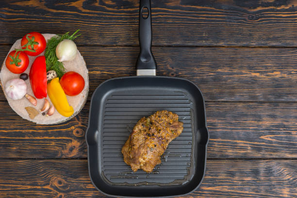 vista de alto ângulo de carne preparada num grelhador pan ao lado de legumes na mesa de madeira - meat quail game meat skillet - fotografias e filmes do acervo