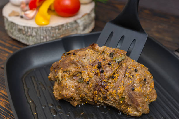 крупным планом кухонный шпатель распространяет подготовленное мясо на сковороде-гриль рядом с овощами - meat quail game meat skillet стоковые фото и изображения