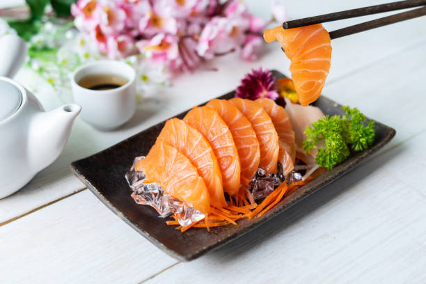 istock Salmon sashimi slice fresh serve on ice with tea, Japanese style 953451592
